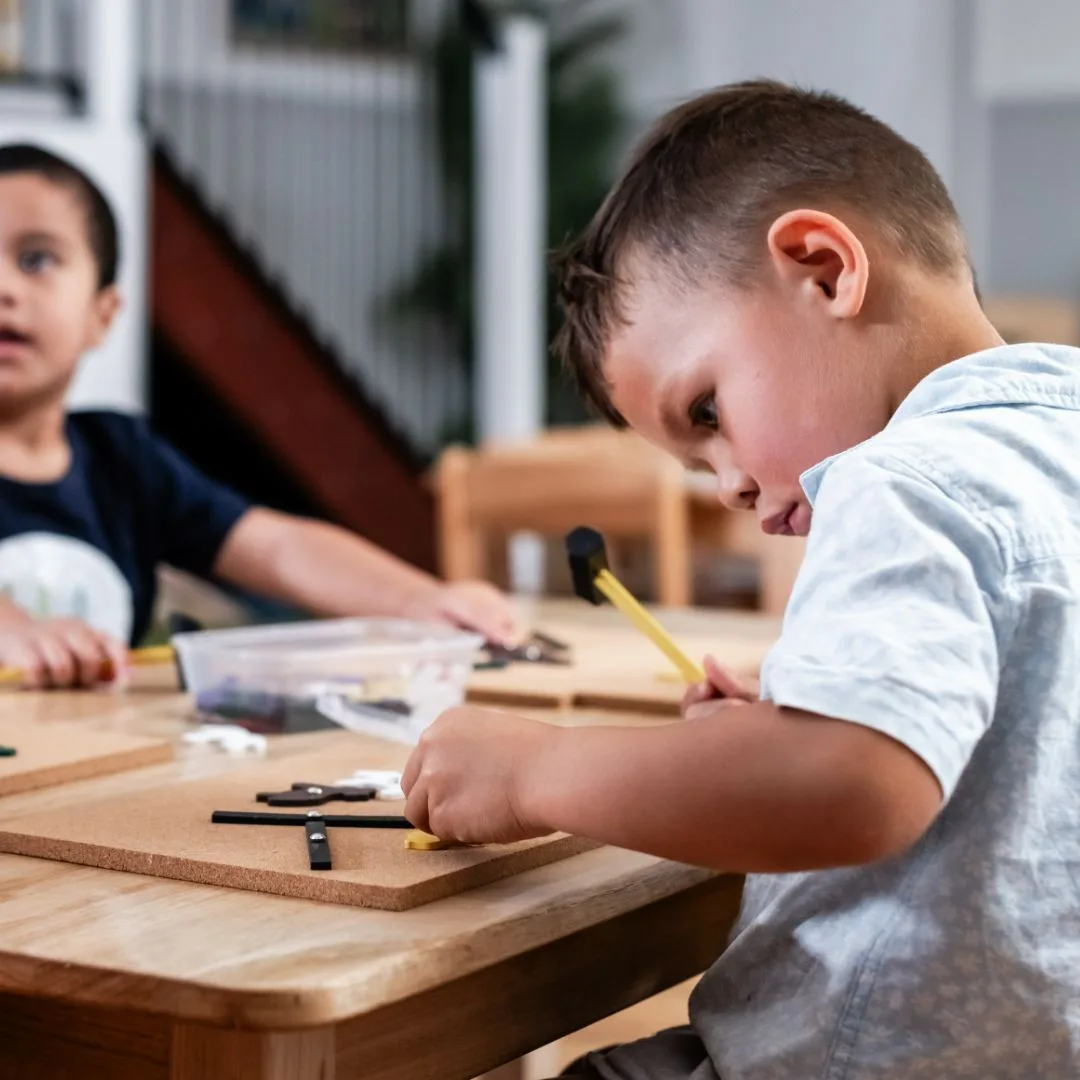 Children practising hammering at the supervised woodwork station