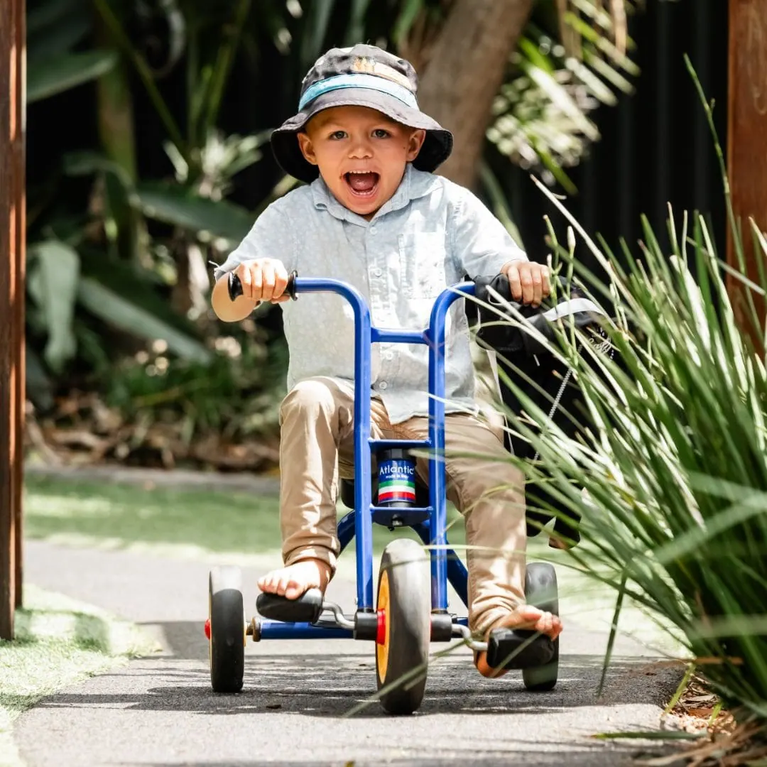 Child riding a trike along the garden pathway at Natural Elements Eagleby